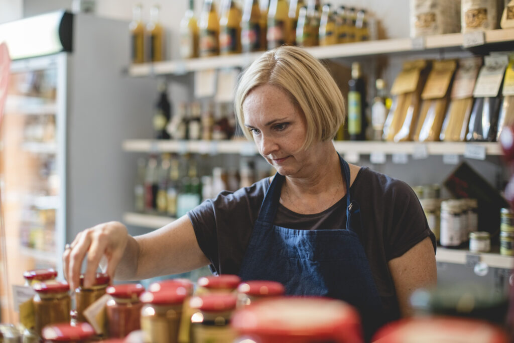 Säljare ställer fram burkar i delikatessbutik